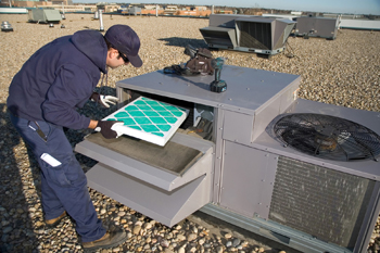 Sam is replacing the air filter on a HVAC unit